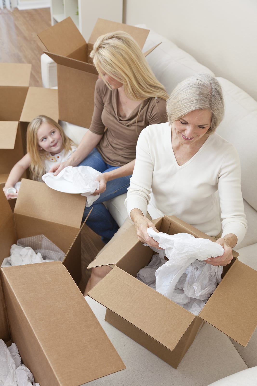 Female generations of a family, mother, daughter & grandmother u Female generations of a family, mother, daughter & grandmother unpacking boxes and moving into a new home.