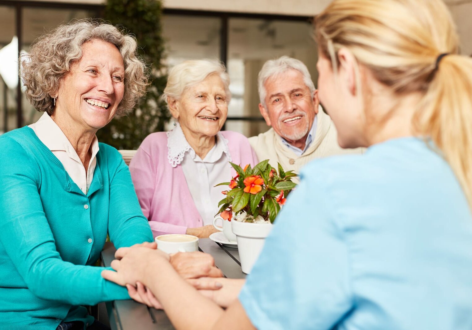 Caregiver takes care of a group of happy seniors in the retirement home